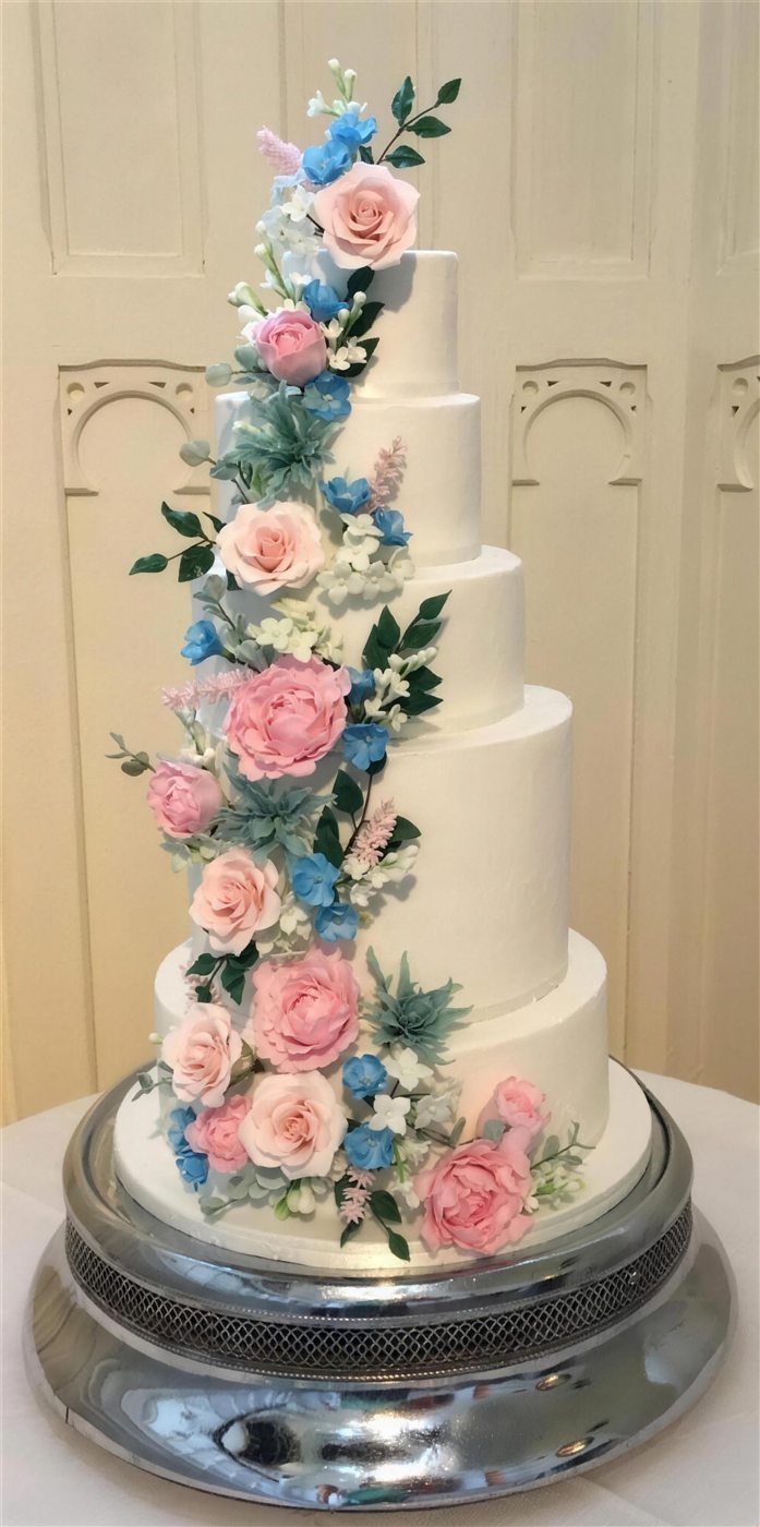 Five-tier wedding cake with a cascade of sugar flowers