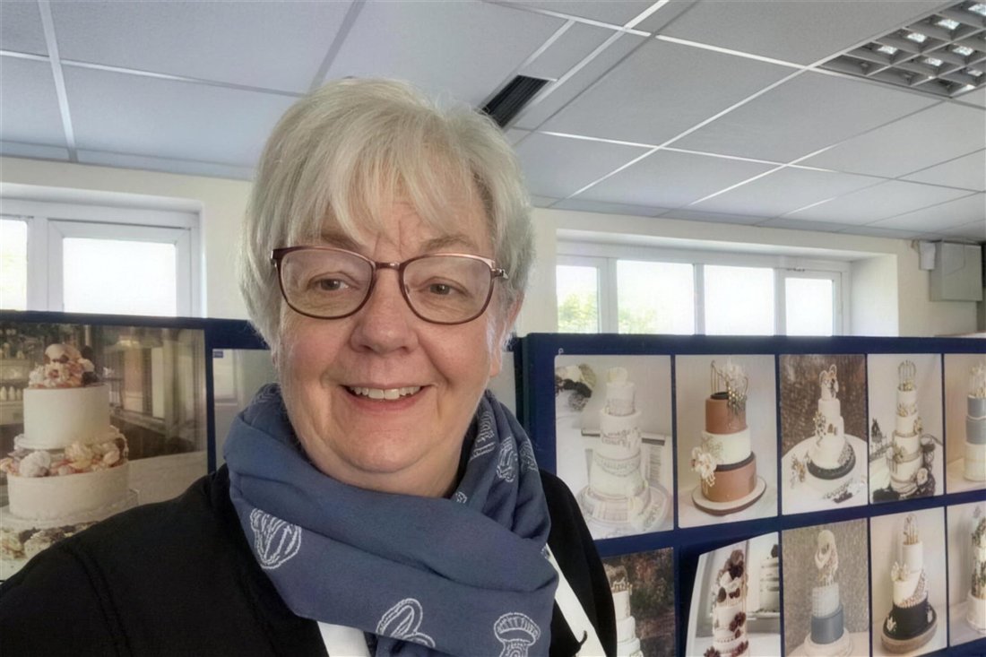 Catherine Scott in her studio in front of a display of her wedding cakes