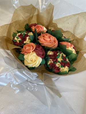 Autumnal cupcake bouquet with piped buttercream roses in orange, red and cream, gift-wrapped