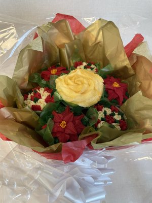 Christmas cupcake bouquet with piped buttercream poinsettias and a cream rose, gift-wrapped
