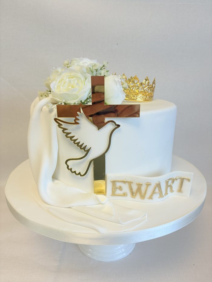 Christening cake with a sugar cross, dove and gold detail on a draped white iced finish