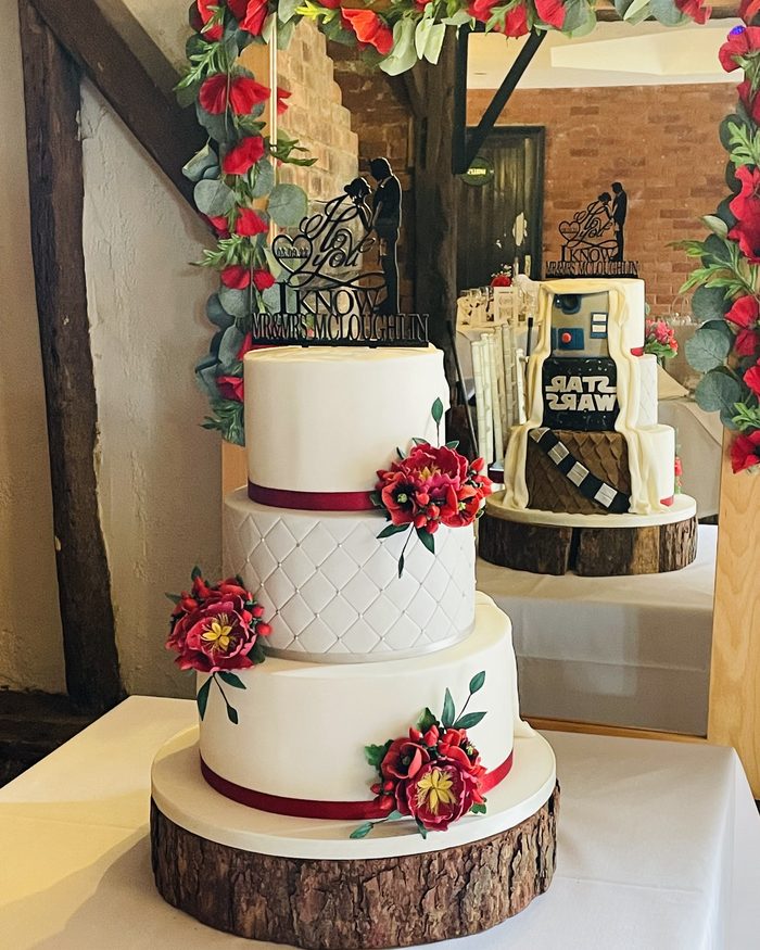 White and red novelty wedding cake with a Star Wars topper by Catherine Scott
